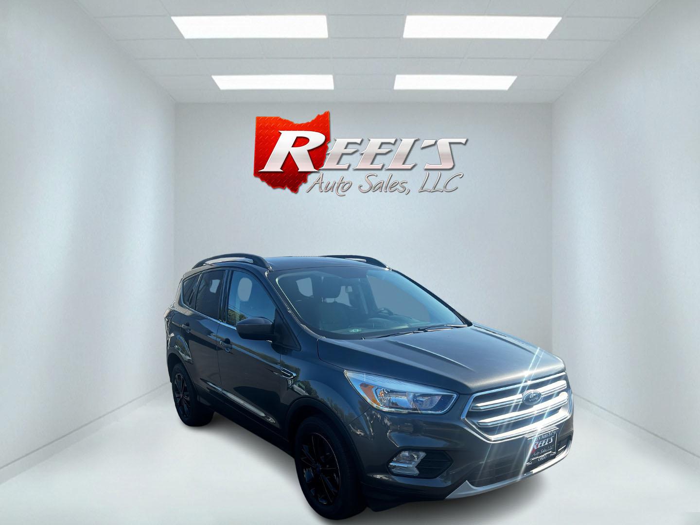 2018 Gray /Black Ford Escape SE 4WD (1FMCU9GD0JU) with an 1.5L I4 DOHC 16V TURBO engine, 6 Speed Auto transmission, located at 547 E. Main St., Orwell, OH, 44076, (440) 437-5893, 41.535435, -80.847855 - This 2018 Ford Escape SE 4WD is a compact SUV designed for efficiency and comfort, powered by a 1.5-liter turbocharged I4 EcoBoost engine, paired with a 6-speed automatic transmission, achieving an impressive 28 MPG on the highway. This Escape incorporates Auto Start Stop technology to enhance fuel - Photo#2