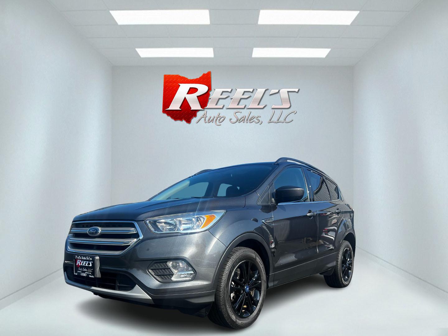 2018 Gray /Black Ford Escape SE 4WD (1FMCU9GD0JU) with an 1.5L I4 DOHC 16V TURBO engine, 6 Speed Auto transmission, located at 547 E. Main St., Orwell, OH, 44076, (440) 437-5893, 41.535435, -80.847855 - This 2018 Ford Escape SE 4WD is a compact SUV designed for efficiency and comfort, powered by a 1.5-liter turbocharged I4 EcoBoost engine, paired with a 6-speed automatic transmission, achieving an impressive 28 MPG on the highway. This Escape incorporates Auto Start Stop technology to enhance fuel - Photo#0