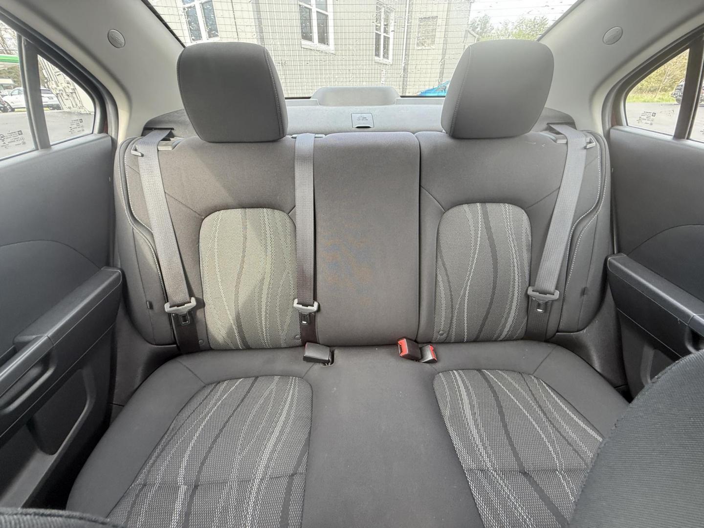 2015 Red /Black Chevrolet Sonic LT Auto Sedan (1G1JC5SH8F4) with an 1.8L I4 DOHC 24V engine, 6-Speed Automatic transmission, located at 11115 Chardon Rd. , Chardon, OH, 44024, (440) 214-9705, 41.580246, -81.241943 - FRESH TRADE IN ALERT ---- This 2015 Chevrolet Sonic LT Sedan with a 1.8L I4 EcoTec engine and 6-speed automatic transmission offers a blend of efficiency and convenience, achieving up to 34 MPG on the highway. Standard features include daytime running lights, dusk-sensing headlights for enhanced sa - Photo#25